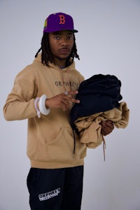 a man holding a hoodie and a pair of pants