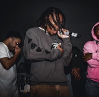 a man in a pink hoodie is holding a microphone